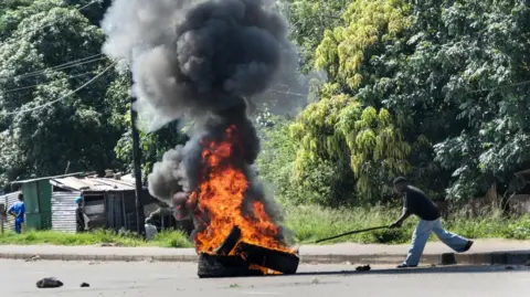 EPA A protester sets fire to tires during a demonstration during the inauguration ceremony of Mozambique's fifth president, Daniel Chapo, in Maputo, Mozambique, 15 January 2025