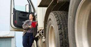female driver standing outside truck 1200x628.jpg